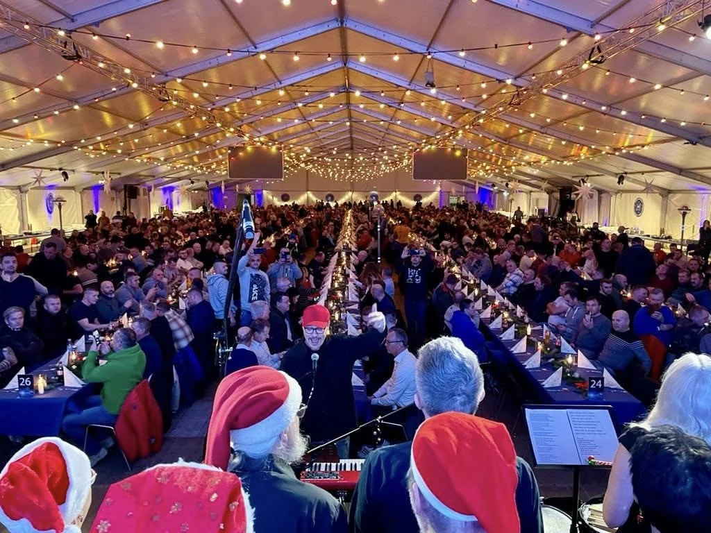 Deltagere samlet til et musikarrangement i et festtelt
